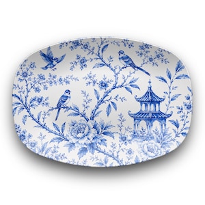 Könnte beinhalten: Eine ovale Keramikplatte mit weißem Untergrund und blauem Transferdruck-Muster. Das Design zeigt detaillierte Blumenranken, drei kleine Vögel und eine Pagode, die in einem feinen, einfarbigen blauen Stil dargestellt sind.