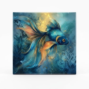 May include: A square canvas print featuring a watercolor illustration of a goldfish. The fish has flowing blue and gold fins and tail, set against a blue and gold underwater background with aquatic plants.
