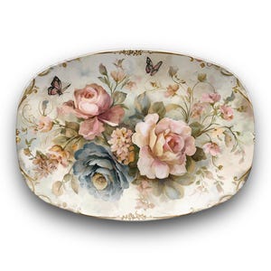 May include: Oval decorative plate with a floral design. The plate features pink and blue roses, butterflies, and gold trim. The flowers are painted in a watercolor style, with soft colors and delicate details.