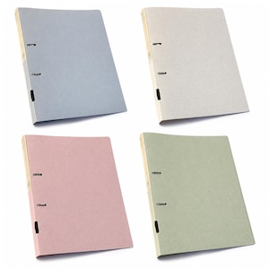 May include: Four ring binders in light blue, beige, dusty pink, and sage green. Each binder features a textured cover, a light-coloured spine, and two metal ring mechanisms on the left side for securing documents, presented in a grid layout.