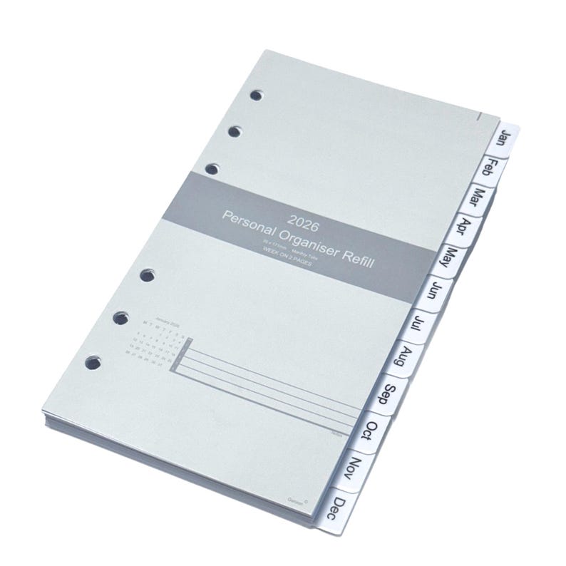 May include: A light gray personal organizer refill for 2026. The refill has a gray band with the text "Personal Organiser Refill" and month tabs. The tabs are labeled from January to December. The refill has a calendar and lines for notes.
