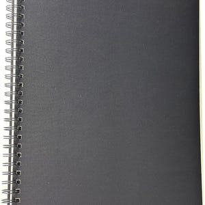 May include: A black spiral bound sketchbook with a textured cover.