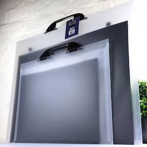 May include: Two clear plastic document folders with black handles. The larger folder has a blue label with the word "ICON" printed on it. The folders are stacked on top of each other.