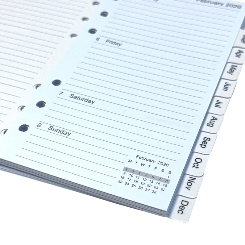 May include: Open planner pages with lined paper, showing the days of the week, including Friday, Saturday, and Sunday. The calendar for February 2026 is visible, along with monthly tabs. The pages have multiple holes for binding.