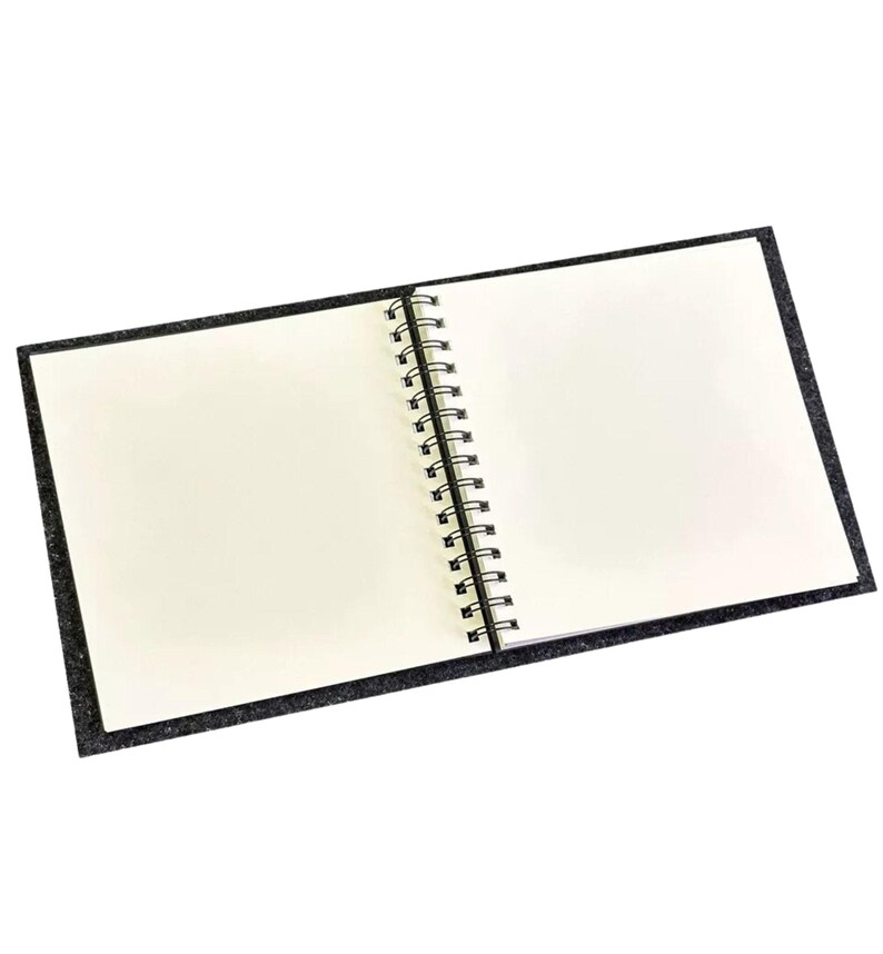 May include: A black spiral bound notebook with a soft, textured cover. The notebook is open to a blank page.