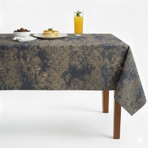 May include: A rectangular tablecloth with a dark blue and gold abstract pattern. The table is set with a bowl of berries, a stack of pancakes, and a glass of orange juice. The table has brown wooden legs.
