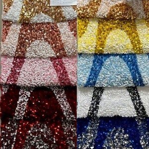 Puede incluir: Una colección de muestras de tela con diferentes colores y patrones de lentejuelas. Las muestras están dispuestas en filas, con cada fila mostrando un color y un patrón diferente. Los colores incluyen dorado, amarillo, azul claro, blanco, rojo, azul y negro. Los patrones incluyen formas geométricas, rayas y lunares.