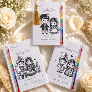 May include: Wedding pack favors with cartoon illustrations of a bride and groom, each with a rainbow crayon. The text on the pack reads "Wedding Pack" and "Thank you for Sharing our Special day."