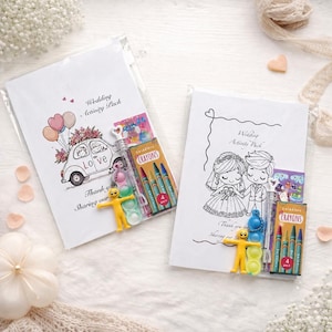 May include: Two white Wedding Activity Packs with illustrations. One pack features a car with flowers and balloons, the word "Love", and a crayon pack. The other pack has a bride and groom illustration and a crayon pack.