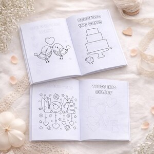 May include: Four open coloring books with wedding-themed illustrations. One book shows two birds with a heart, another has a cake, and the others have the words "LOVE" and "Trace and Colour". The books are on a white surface.
