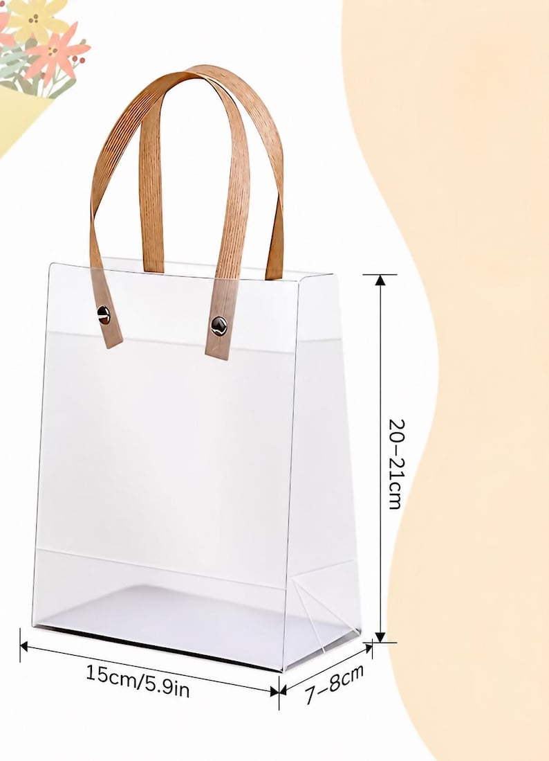 May include: Clear rectangular tote bag with wooden handles. The bag is 15cm (5.9in) wide, 7-8cm deep, and 20-21cm (7.9-8.3in) tall. The handles are attached with metal rivets. The bag is empty and sits on a light background.
