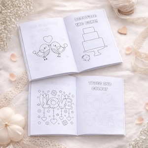 May include: Four open coloring books with wedding-themed illustrations. One book shows two birds with a heart, another has a cake, and the others have the words "LOVE" and "Trace and Colour". The books are on a white surface.