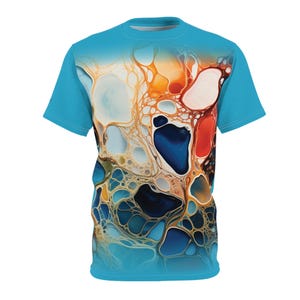 May include: A turquoise blue t-shirt with a colorful abstract design. The design features a swirling pattern of blue, orange, red, and white paint.