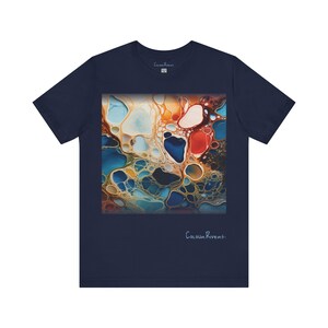 May include: Navy blue t-shirt with a colorful abstract design featuring swirling patterns of blue, orange, yellow, and red. The design is reminiscent of liquid paint. The text "Colour Rivers." is printed on the bottom of the shirt.