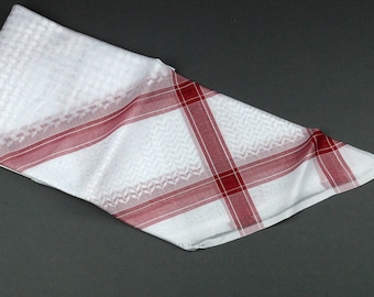 May include: White and red checkered keffiyeh, a traditional Arab headdress.