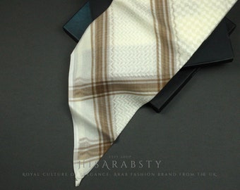 May include: A white and brown patterned keffiyeh, a traditional Arab headdress, folded on a black surface. The keffiyeh has a checkered pattern with brown stripes.