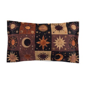 Può includere: Una federa rettangolare con un design celeste. La federa è divisa in quadrati con illustrazioni di sole, luna e stelle in tonalità marroni, beige e nere. La federa è realizzata in un materiale morbido e confortevole.