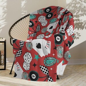 May include: Red and white throw blanket with a repeating pattern of playing cards, dice, 8-ball pool balls, turquoise gemstones, and black and white checkered patterns.