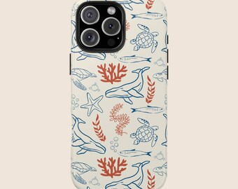 May include: A white phone case with a blue and red ocean-themed pattern. The pattern includes whales, sea turtles, coral, and fish.