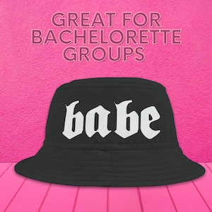 May include: Black bucket hat with the word "babe" in white gothic lettering.