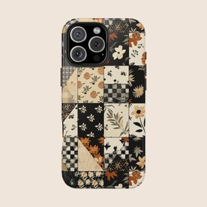 May include: A phone case with a patchwork design featuring floral and geometric patterns in black, white, beige, and orange. The case has a glossy finish and a camera cutout.