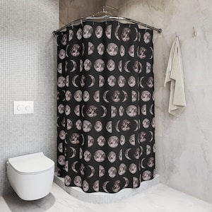 May include: A black shower curtain with a repeating pattern of moon phases in grey and white. The curtain is displayed in a bathroom, adding a celestial theme to the decor.