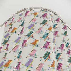 Può includere: Una tenda da doccia bianca con un motivo ripetuto di sedie a sdraio colorate. Le sedie presentano disegni a righe e fantasia nei toni del rosa, arancione, verde e blu. La tenda è appesa a un'asta di metallo curva.