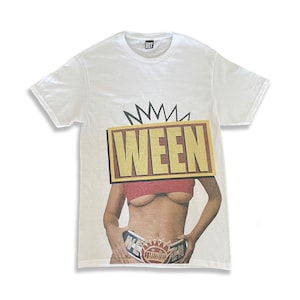 Puede incluir: Camiseta blanca con un gráfico de una mujer con un top rojo y un cinturón con la palabra "WEEN". La palabra "WEEN" también está impresa en letras doradas grandes sobre un fondo amarillo y rojo.
