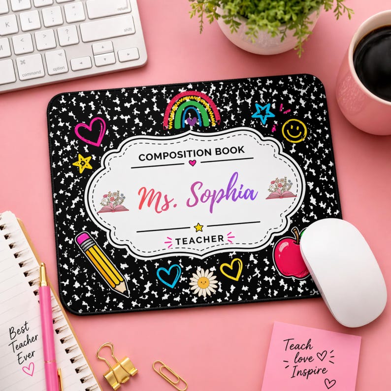 Pu&ograve; includere: Un tappetino per mouse nero e bianco in stile quaderno con il nome "Ms. Sophia" e la parola "TEACHER". Il tappetino per mouse presenta un arcobaleno, cuori, stelle e un design a matita. Un mouse bianco &egrave; sulla destra.