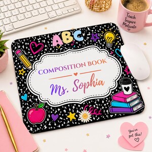 Pu&ograve; includere: Un tappetino per mouse personalizzato con un design a quaderno. Il tappetino presenta il testo "COMPOSITION BOOK" e "Ms. Sophia" in uno stile colorato e scritto a mano. &Egrave; decorato con elementi grafici a tema scolastico come una mela, una matita e le lettere ABC.