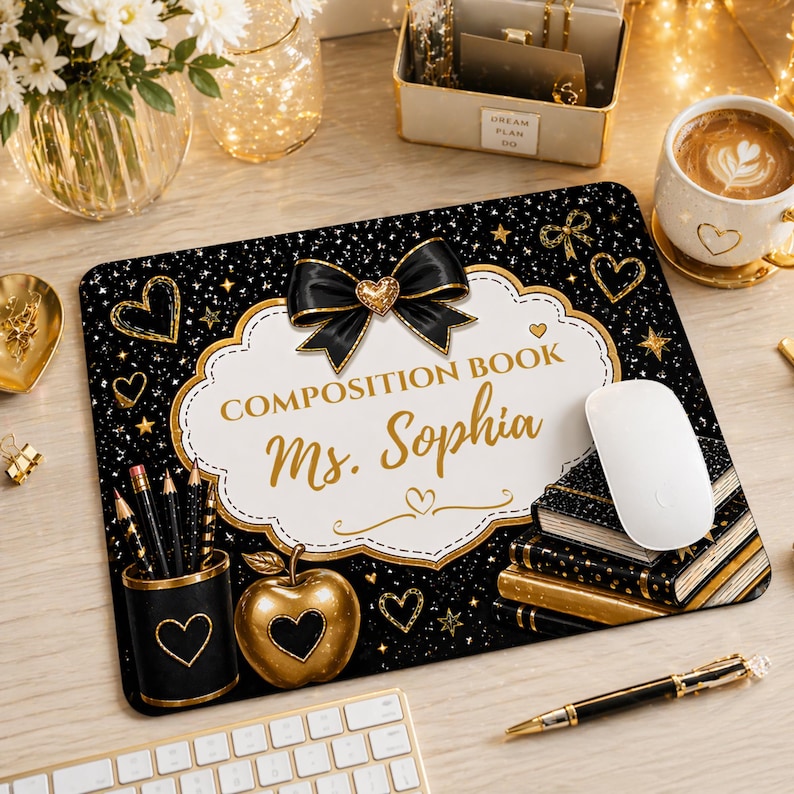 Pu&ograve; includere: Tappetino per mouse nero con un design oro e bianco. Il tappetino presenta un fiocco nero, cuori, stelle e il testo "COMPOSITION BOOK Ms. Sophia". Sono visibili anche una mela dorata e una pila di libri.