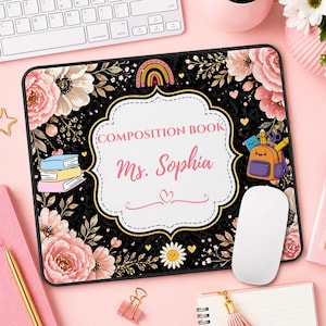 Pu&ograve; includere: Un tappetino per mouse rettangolare nero con un design floreale e la scritta "COMPOSITION BOOK Ms. Sophia". Il tappetino presenta un bordo bianco, un arcobaleno e una pila di libri.