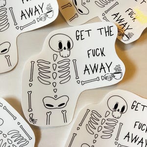 Może przedstawiać: Kolekcja białych naklejek z czarno-białym wzorem szkieletu. Każda naklejka zawiera napis "GET THE FUCK AWAY" wraz z małą ilustracją filiżanki kawy.