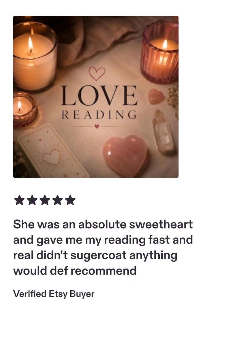 May include: A beige surface featuring the text LOVE READING with a small heart icon above and below the word LOVE. Three lit candles in glass holders, a deck of tarot cards, a heart-shaped pink crystal, and a clear crystal point are arranged.