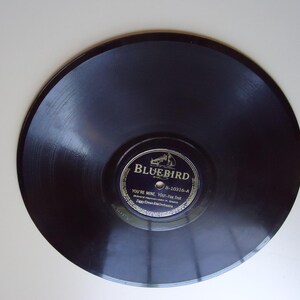 May include: A black vinyl record with a gold label that reads "Bluebird B-10316-A You're Mine, You're Mine - Fox Trot Eddy Duchin and His Orchestra".
