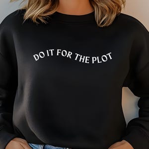 May include: Black sweatshirt with white text that reads "DO IT FOR THE PLOT".