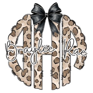 May include: A monogram design featuring the name "Braylee Rae" in a script font. The letter outline is a leopard print pattern, with a black bow at the top. The design is set against a white background.