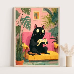 May include: A framed art print depicting a black cat with yellow eyes engrossed in a video game. The cat sits on a yellow sofa against a pink wall, with potted plants around. The artwork has a playful, cartoon-like aesthetic.