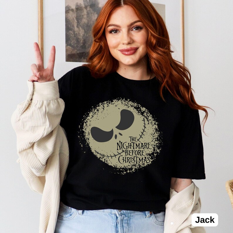 Puede incluir: Camiseta negra con un gr&aacute;fico desgastado de la cara de Jack Skellington de la pel&iacute;cula "Pesadilla antes de Navidad". El texto "The Nightmare Before Christmas" est&aacute; impreso debajo del gr&aacute;fico.
