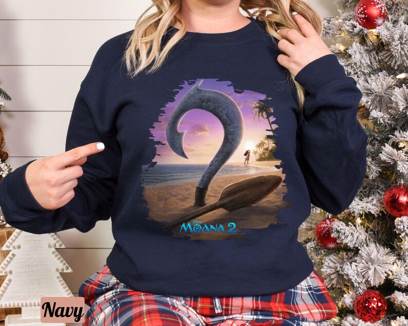 Puede incluir: Una sudadera azul marino con un gr&aacute;fico de un gancho y un barco de la pel&iacute;cula Moana 2. El gr&aacute;fico est&aacute; en un esquema de color blanco, azul y naranja.