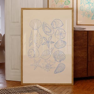 May include: A framed print with a blue and white illustration of various seashells, starfish, and sand dollars. The print is on a light beige background and is framed in a light wood frame.