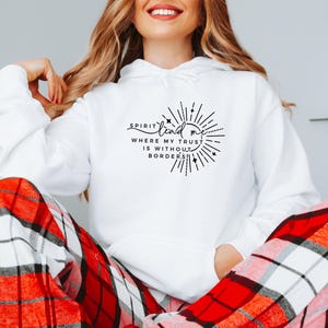 May include: White hoodie with a black graphic that says "Spirit lead me where my trust is without borders". The graphic is a sunburst with stars.