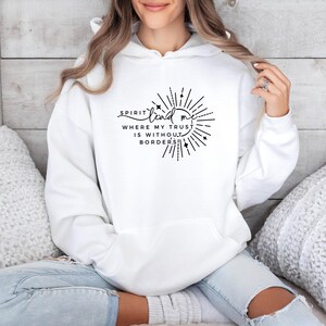 May include: White hoodie with a black graphic that says "Spirit lead me where my trust is without borders".