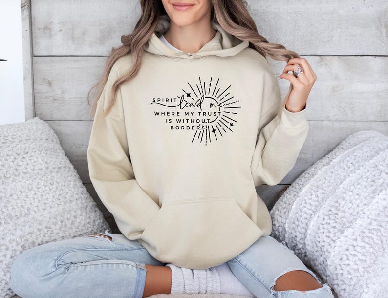 May include: A beige hoodie with a black graphic that says "Spirit lead me where my trust is without borders".