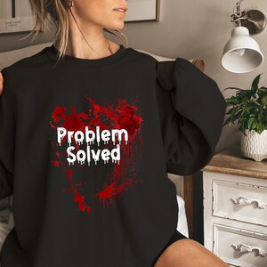 May include: Black sweatshirt with a red blood splatter design and the text "Problem Solved" in white.