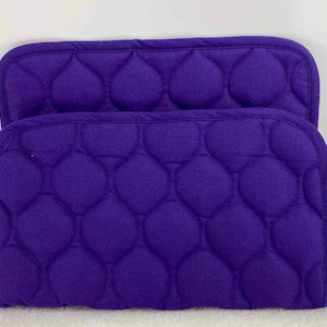 May include: Two purple quilted pot holders with a diamond pattern.