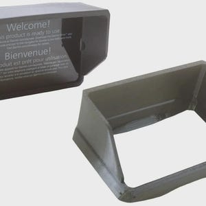 May include: Two grey plastic cases, one open and one closed. The closed case has the text "Welcome! This product is ready to use. Bienvenue! Ce produit est prêt pour utilisation". The cases are likely designed to hold a small electronic device.