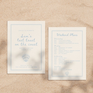 May include: Two cream-colored cards with light blue text and borders. The left card reads "Sam's last toast on the coast" with a seashell graphic. The right card lists weekend plans. The cards are on a sandy surface.