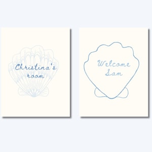 May include: Two white signs with blue seashell designs. The first sign says "Christina's room" and the second sign says "Welcome Sam".