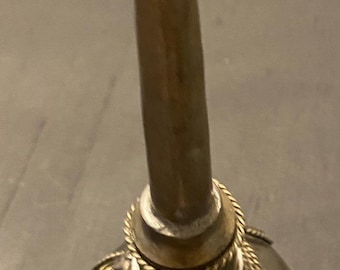 May include: A clear glass bottle with a gold metal top and intricate detailing. The bottle has a long, slender neck and a round body. The bottle is decorated with a gold metal band around the top and a gold metal chain around the bottom.